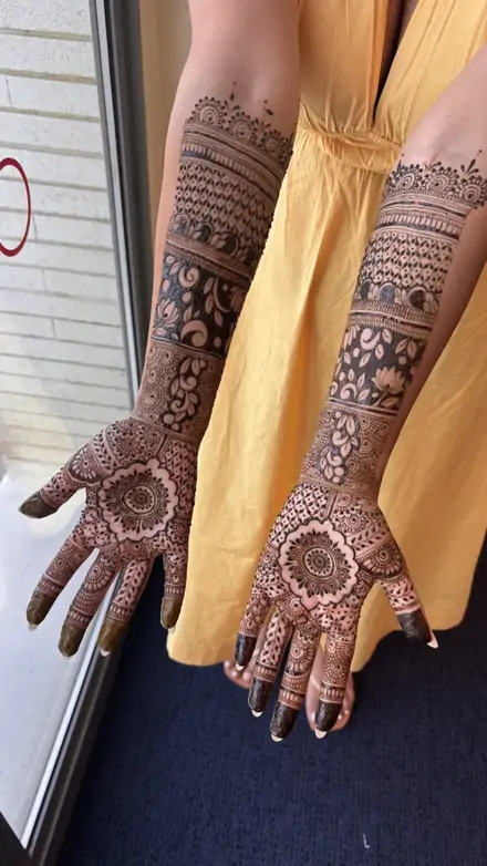 Bridal mehndi on full arms at a haldi ceremony